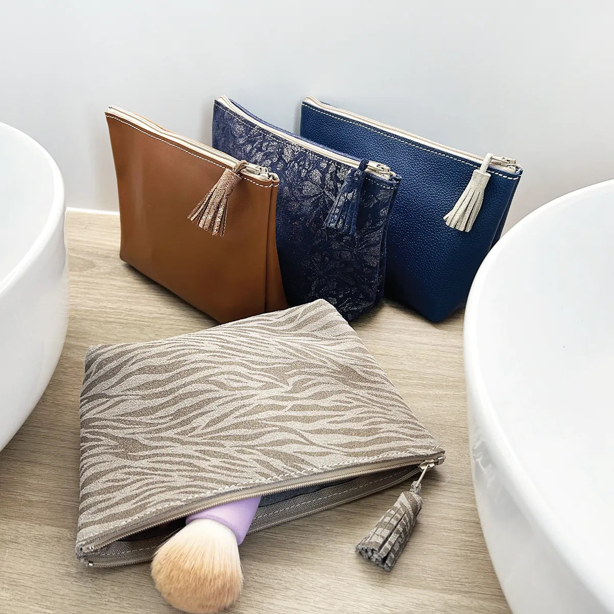 Livre et patron Deco Cuir pour réaliser une trousse en cuir, montrant la couverture et des exemples de couture.
