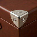 Coin de valise installé sur une malle avec des rivets nickelés