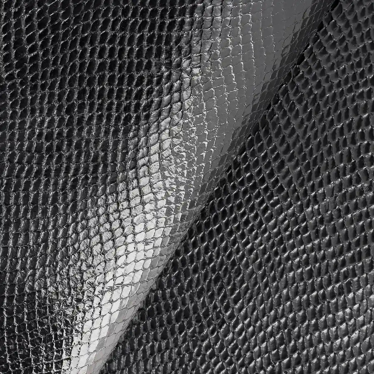 Zoom sur le cuir de chèvre fantaisie noir à motif façon peau de reptile.