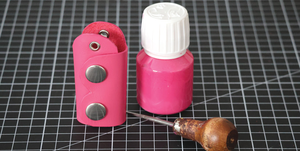 Dyeing the edges of a pink leather keychain DIY for Breast Cancer Awareness Month